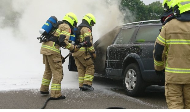 Brandweerlieden blussen de autobrand.
Foto Inter Visual Studio / Marcel Winter