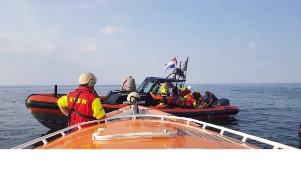 De KNRM verleent hulp aan de gewonde man op de RIB.
