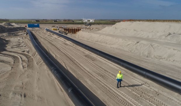 Hoogheemraad Kees Stam van Hollands Noorderkwartier bekijkt de nieuwe buizen tussen het PH-gemaal en de Waddenzee.