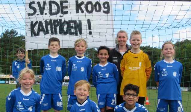 De kampioenen van De Koog. Op de foto van links naar rechts: Achterste rij: Niek Spek (speler JO12 met spandoek), Jurjen Stolk, Mees Witte, Awos Aboudi, Karin de Boer (trainer/coach), Tygo Ran, Sophie Snoek. Voorste rij: Evy de Boer, Dexx Kikkert, Ziad El Assy.