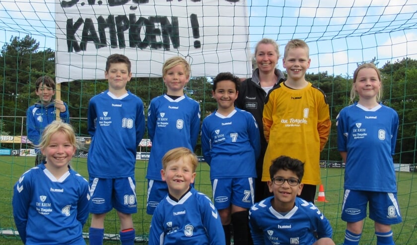 De kampioenen van De Koog. Op de foto van links naar rechts: Achterste rij: Niek Spek (speler JO12 met spandoek), Jurjen Stolk, Mees Witte, Awos Aboudi, Karin de Boer (trainer/coach), Tygo Ran, Sophie Snoek. Voorste rij: Evy de Boer, Dexx Kikkert, Ziad El Assy.