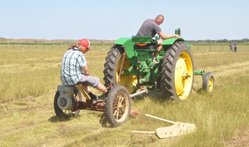 Nico Schipper en Ruud Spoelstra maaien het gras bij een wedstrijd in 2017.