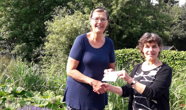 Karen Keijser overhandigt de opbrengst aan Lidwien de Ruiter van Hospice Texel.