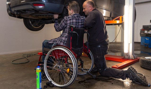 Hylke Walstra sleutelt samen met Kylian aan een auto.