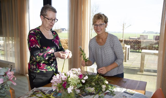 Een bewoner en medewerker van Herbergier Bartlehiem maken er een leuke middag van door samen te bloemschikken.