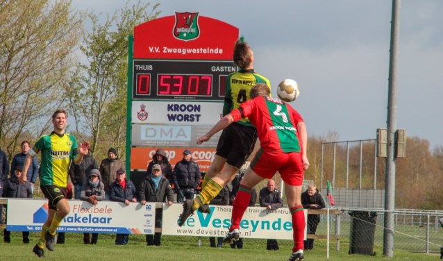 Henk van der Wal, maker van de gelijkmaker van VV Zwaagwesteinde (nummer 4) in duel met Martin Kool van Ropta Boys. Links Kees Kool.