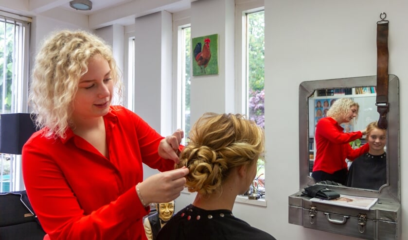 Esra van der Meer heeft thuis ook een kleine kapsalon om te oefenen. Ze steekt het haar op van haar model Rianne Jongboom.