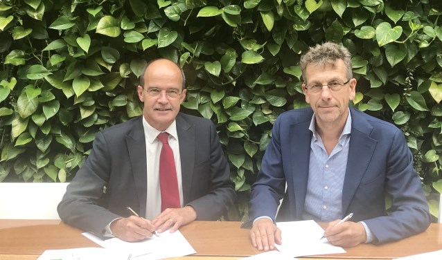 Burgemeester Alex van Hedel en directeur Marco de Wilde ondertekenen de koopovereenkomst.