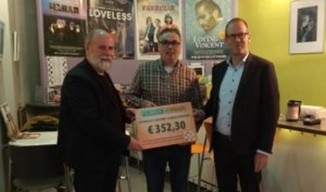 Voorzitter Harri de Vries overhandigt de cheque aan Thomas Povel en Leon Vliegen van HDKT (foto: Filmhuis Zevenaar)