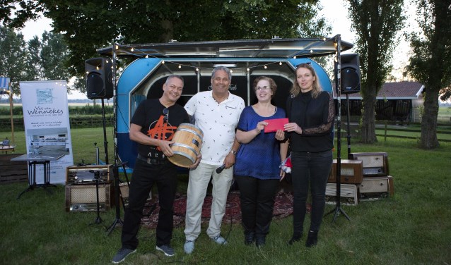 Patrick Beverloo heeft symbolisch het eerste vaatje haring ontvangen van MKB Montferland voorzitter Edwin Sap. Rechts op de foto José Broekhof en Linsy Tjalkens, de juffen van de St. Jozefschool die de opbrengst van de veiling in ontvangst namen. (foto: Dies Goorman)