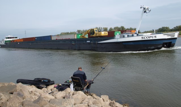 Deze foto is gemaakt op de Rijn, met een lengte van 109 meter en 35,05 breed. De visser valt hierdoor in het niets weg als zo'n groot schip passeert. (foto: Frans Willemsen)