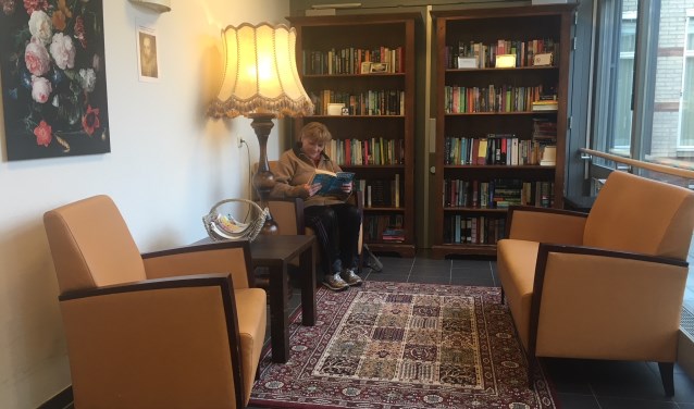 Een bezoekster van De Lingehof, die een boek leest in ons boeken-ruil-kast hoekje. (foto: Bianca)